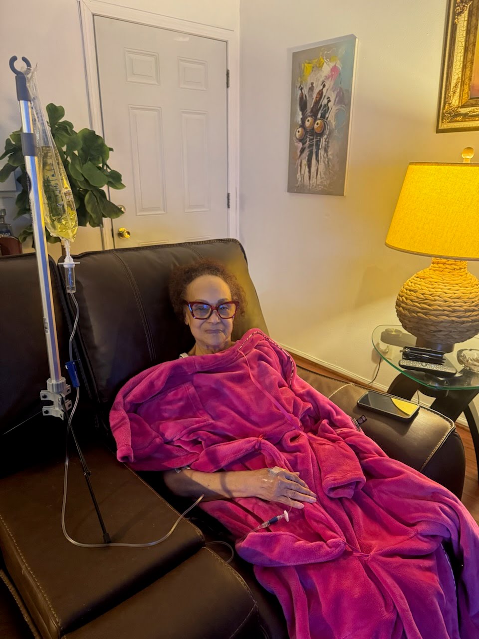 Revive Wellness client relaxing under a blanket while receiving a mobile IV drip at home in Los Angeles