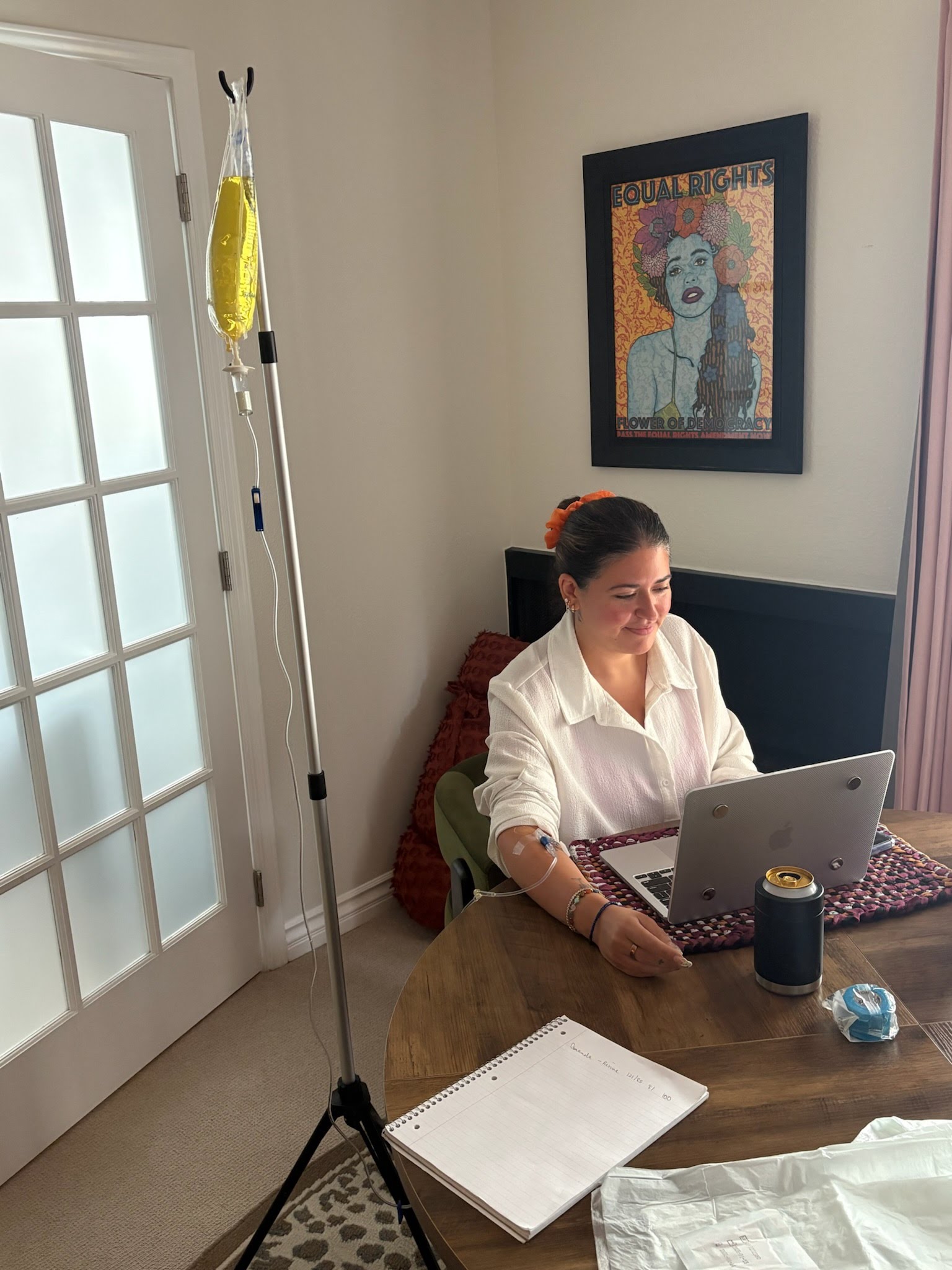 Revive Wellness client working at her laptop at home in Los Angeles while receiving a mobile IV drip